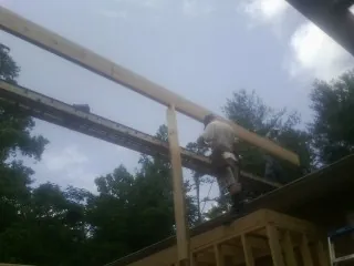 Carpenter setting a ridge beam over a new addition frame — Ice Dam Removal by Roofing Brothers in Moscow Mills