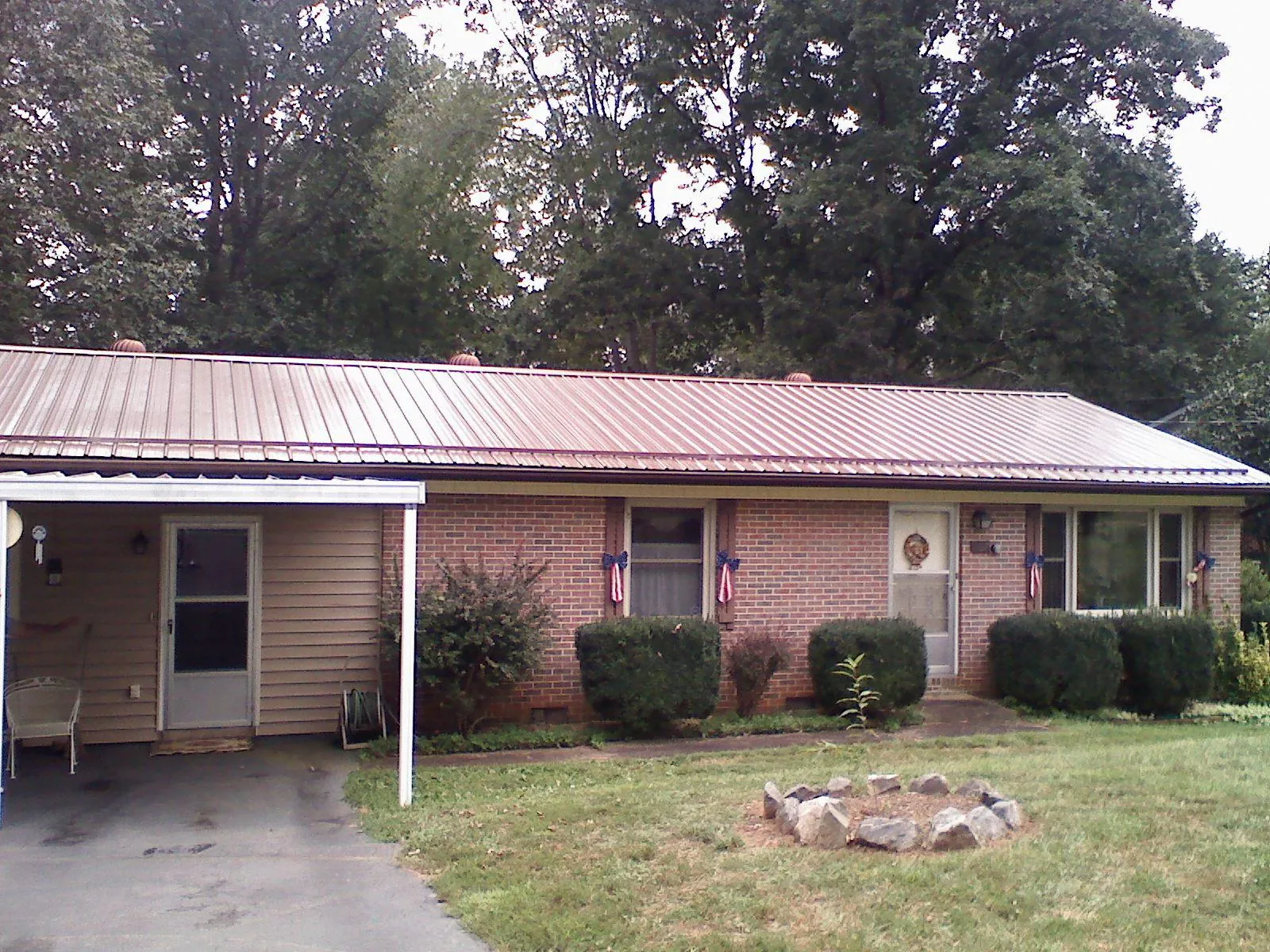 Bronze metal roof and carport on a brick ranch home — Roof Repair work by our crew in Moscow Mills
